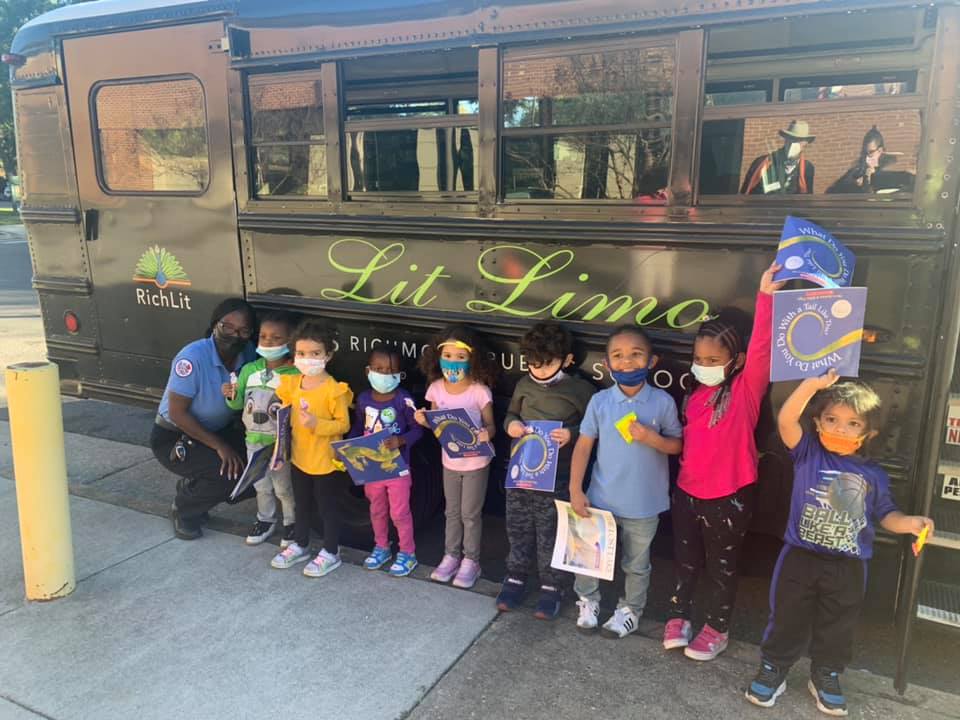 Operator Kelsey with a group of kids in front of the Lit Limo bus
