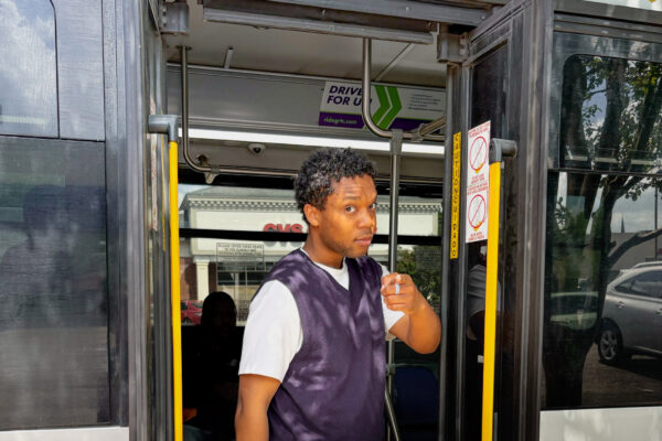 young rider standing in the open door of a bus pointing at the viewer, in reference to the Uncle Sam recruitment post